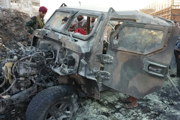 Aden yakınlarında meydana gelen aracına yönelik bomba saldırısının ardından güvenlik görevlileri olay yerini inceliyor (EPA)