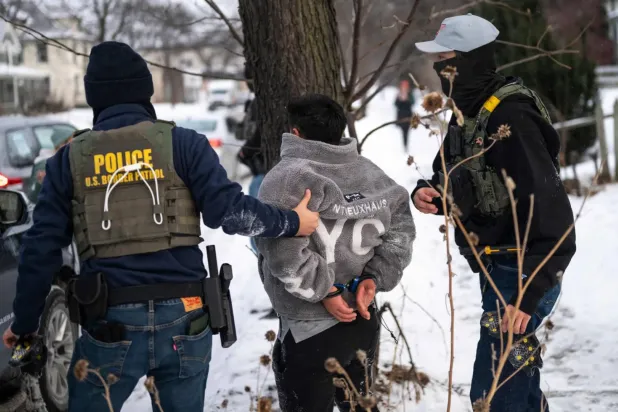 ICE polisleri Minneapolis'te bir kişiyi tutuklarken (AFP)