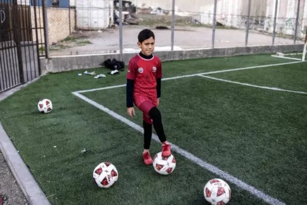 Aida Mülteci Kampı’ndaki bir futbol sahasında top oynayan Filistinli bir çocuk (AFP)