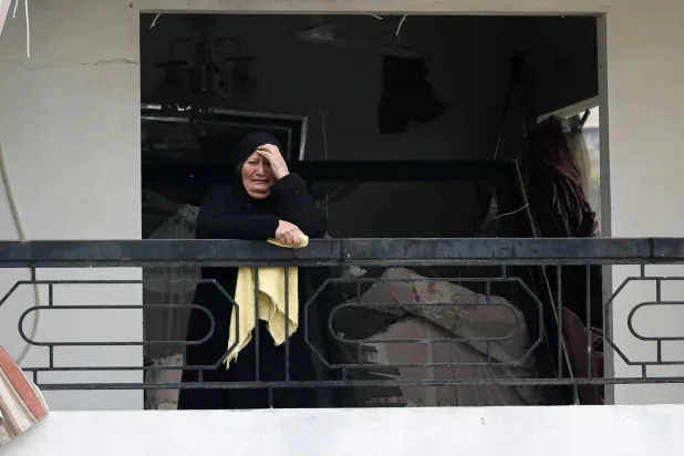 لبنانية متأثرة من الدمار الذي خلفته الغارات الإسرائيلية على بلدة قناريت الجنوبية الأربعاء (إ.ب.أ)