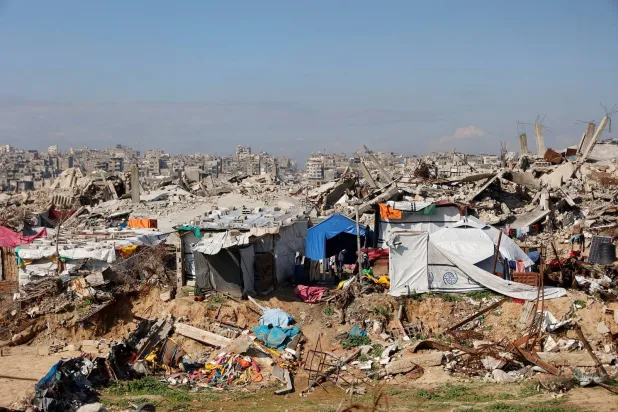 فلسطينيون نازحون يعيشون وسط الأنقاض والحطام الذي خلّفه الجيش الإسرائيلي في مخيم جباليا للاجئين شمال قطاع غزة (أ.ف.ب)