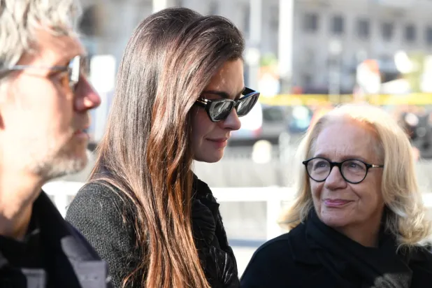 US actor Anne Hataway (C), along with her husband Adam Shulman (L), arrives to attend Valentino Garavani's funeral at the Basilica of S. Maria degli Angeli e dei Martiri in Rome, Italy, 23 January 2026. (EPA)