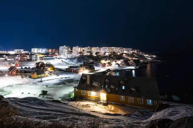 Apartment buildings and houses light up the city of Nuuk, Greenland on January 22, 2026. (AFP)