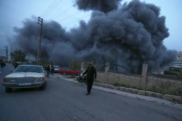 Local residents flee into the street during an Israeli strike on the village of Qanarit in southern Lebanon on Jan. 21 (AP)  