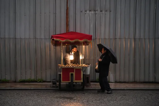  A man selling roasted chestnuts talks to a customer at the Eminonu commercial district, in Istanbul, Türkiye, Friday, Jan. 23, 2026. (AP)