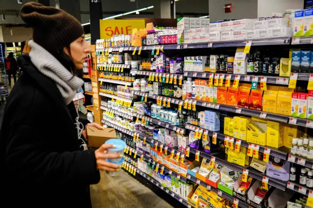 سيدة تتسوق لشراء فيتامينات من محل في نيويورك (أ.ف.ب)