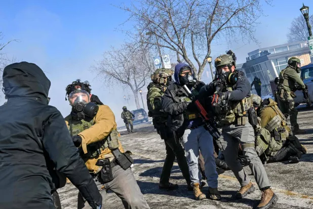 عملاء فيدراليون يعتقلون شخصاً بأحد شوارع مينيابوليس يوم 24 يناير (أ.ف.ب)