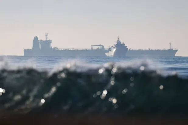 The silhouette of a French navy boat surrounding the GRINCH oil tanker, intercepted by France in the Alboran Sea on suspicion of operating under a false flag and belonging to Russia's shadow fleet that enables Russia to export oil despite sanctions, and diverted to the port of Marseille-Fos, in the Gulf of Fos-sur-Mer, - Reuters