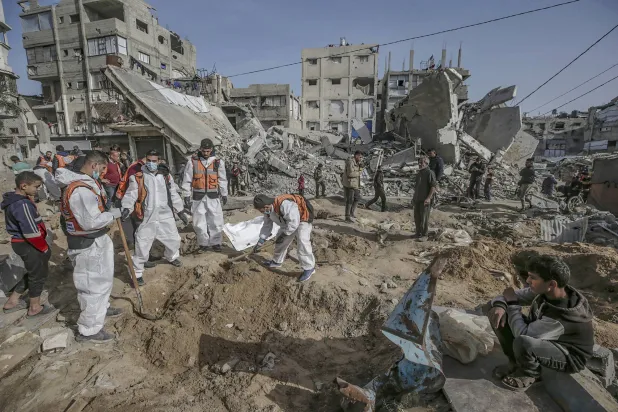 عناصر الدفاع المدني الفلسطيني يبحثون عن جثث ضحايا الحرب الإسرائيلية في ساحة مسجد صلاح الدين بمدينة غزة أمس (إ.ب.أ)