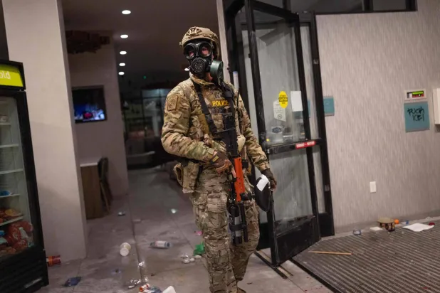 أحد عناصر قوات الأمن الفيدرالية داخل فندق شهد مظاهرات اعتراضاً على إقامة قوات الأمن به في مينيابوليس (أ.ف.ب)