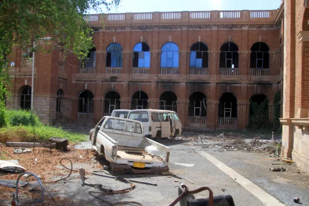 مركبات مدمرة خارج مبنى وزارة المالية بعد مرور نحو 3 سنوات على اشتعال الحرب في السودان (أ.ف.ب)