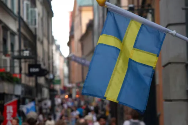 A Swedish flag hangs outside a store on a busy street as visitors walk past in the background in the old town of Stockholm, Sweden, July 14, 2023 REUTERS/Tom Little/File Photo 