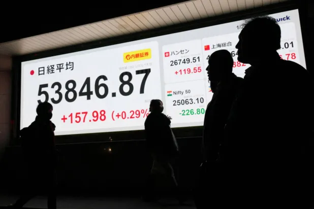 مشاة يمرون أمام شاشة إلكترونية تعرض حركة الأسهم وسط العاصمة اليابانية طوكيو (رويترز)