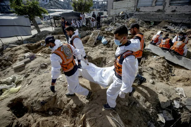 جانب من عملية إعادة دفن جثامين فلسطينيين في حي الزيتون بغزة (إ.ب.أ)