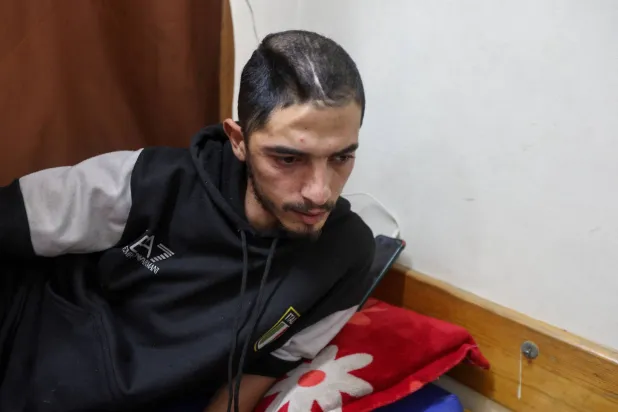 الفلسطيني الجريح محمد السر يرقد على سرير في مستشفى ناصر بخان يونس منتظراً فتح معبر رفح لمواصلة علاجه في الخارج (رويترز)