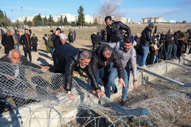Pro-Kurdish protesters tear down a border fence as they attempt to cross to the Kurdish-controlled northeastern Syrian city of Qamishli during a demonstration in support of Syrian Kurds and against recent military clashes between the Syrian army and Kurdish forces, in Nusaybin, southeastern Türkiye, January 20, 2026. REUTERS/Ensar Ozdemir 