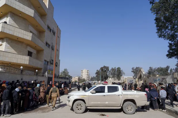 عناصر من «قوات سوريا الديمقراطية» (قسد) بقيادة الأكراد يصطفون لتسوية أوضاعهم مع الحكومة السورية في الرقة بسوريا 27 في يناير 2026 (رويترز)