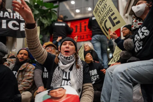 شخص يهتف خلال اعتصام داخل فندق هيلتون يُعتقد أنه يضم عملاء إنفاذ قوانين الهجرة الفيدرالية في نيويورك (إ.ب.أ)