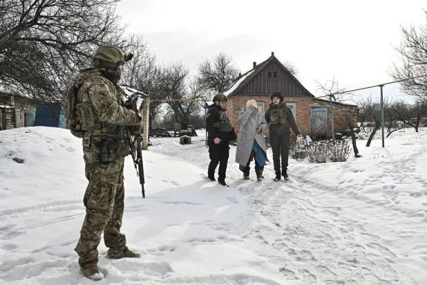 ضباط أوكرانيون يساعدون أحد السكان خلال عملية إجلاء من قرية على خط المواجهة وسط الهجوم الروسي على أوكرانيا في منطقة زابوريجيا (رويترز)