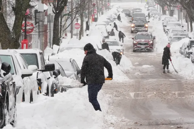Residents dig out their cars in the South Boston neighborhood following a winter storm that dump more than a foot of snow across the region, Monday, Jan. 26, 2026, in Boston. (AP)