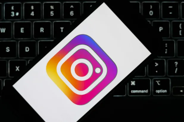 The Instagram logo displayed on a mobile phone alongside a laptop keyboard in Liverpool, Britain, 23 January 2026. (EPA)