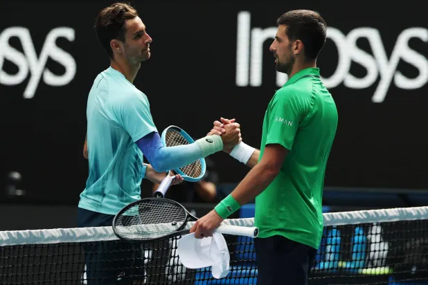 ديوكوفيتش (يمين) يواسي موزيتي الذي انسحب للإصابة وهو متقدم بمجموعتين (رويترز)