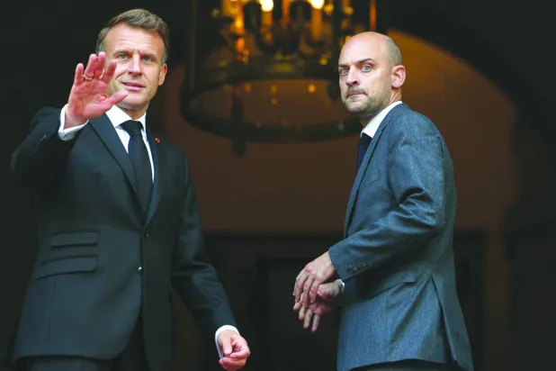 وزير الخارجية الفرنسي جان نويل بارو مستقبلاً الرئيس ماكرون على مدخل وزارته (أ.ب)