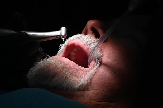 Rubio Dental Group'un Meksika'nın Los Algodones kentindeki ofislerinden birinde, bir diş hekimi Amerikalı hastaya diş tedavisi uyguluyor (AFP)