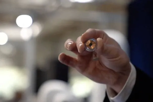 إيلون ماسك يمسك بالشريحة الدماغية المبتكرة (أ.ف.ب)