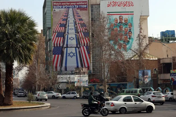 لوحة دعائية مناهضة للولايات المتحدة وإسرائيل على مبنى التنسيق الإيراني - الفلسطيني وسط طهران (إ.ب.أ)