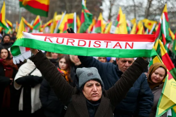 متظاهر يحمل وشاحاً كُتب عليه «كردستان» خلال مظاهرة في برلين 24 يناير احتجاجاً على الاشتباكات العسكرية الأخيرة بين الجيش السوري وقوات «قسد» (رويترز)