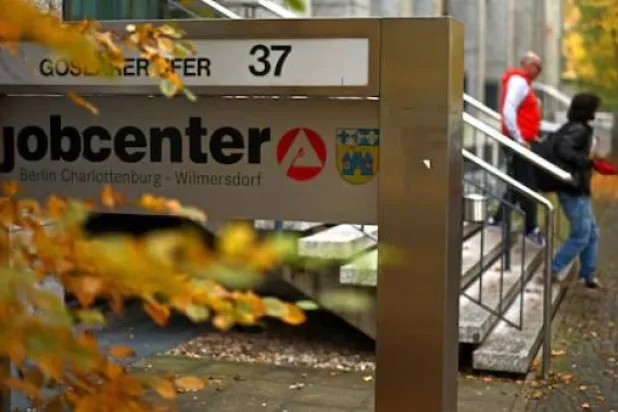 أشخاص يسيرون خارج مركز توظيف في برلين (رويترز)