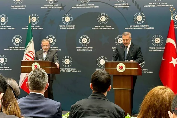 وزيرا الخارجية التركي هاكان فيدان والإيراني عباس عراقجي خلال مؤتمر صحافي في إسطنبول الجمعة (أ.ف.ب)