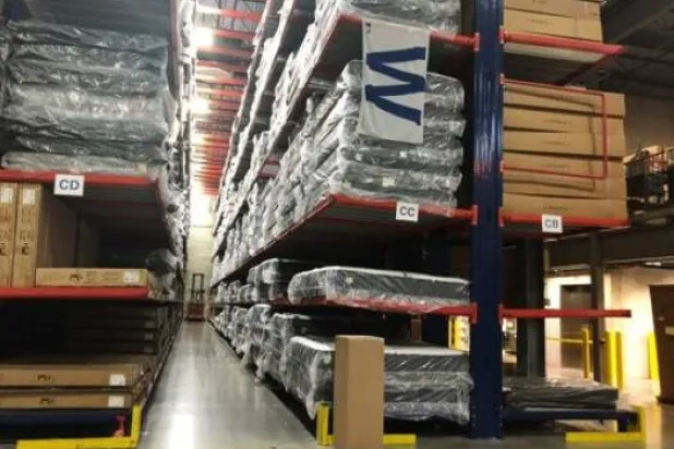 عمال مستودعات «إيه بي تي» للإلكترونيات يتعاملون مع مخزون بمنشأتهم بغلينفيو في إلينوي (رويترز)