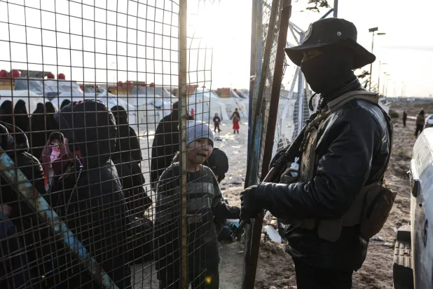 Syrian internal security forces stand guard along the fence of Al-Hol camp in the desert region of Syria's Hasakeh province on January 21, 2026. (AFP)