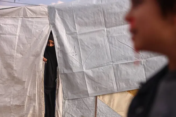  A woman looks out from a tent at Roj camp, one of the detention facilities holding thousands of ISIS group members and their families, in the al-Malikiyah area of northeastern Syria, Thursday, Jan. 29, 2026. (AP) 