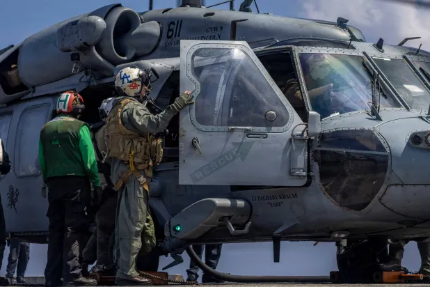 This handout image from the US Navy shows Capt. Daniel Keeler, the commanding officer of the Nimitz-class aircraft carrier USS Abraham Lincoln, as he prepares to fly an MH-60R Sea Hawk helicopter in the Indian Ocean on Jan. 23, 2026. (Mass Communication Specialist Seaman Daniel Kimmelman/US Navy via AP)