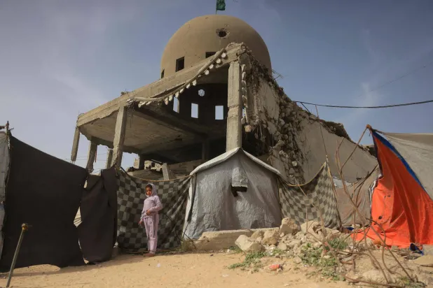 طفلة بجانب منزل مدمر جراء الضربات الإسرائيلية في خان يونس (أ.ف.ب)