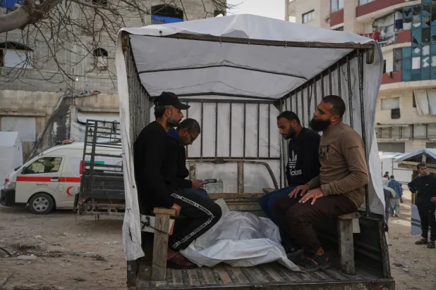 فلسطينيون ينقلون أحد ضحايا القصف الإسرائيلي على مقر للشرطة في قطاع غزة إلى مستشفى الشفاء (أ.ب) 