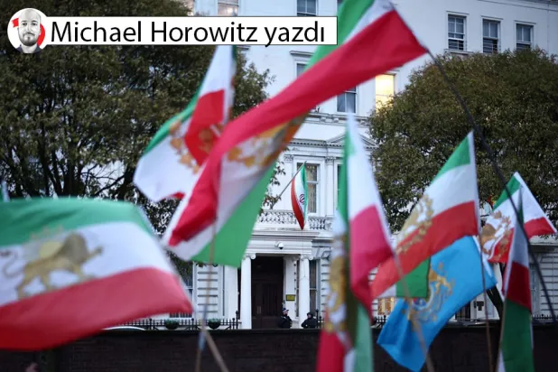  Rejim karşıtı protestocular, Londra'nın merkezindeki İran Büyükelçiliği önünde düzenlenen mitingde, 1979 devriminden önce kullanılan aslan ve güneş amblemli İran bayrağını taşıyor, 9 Ocak 2026 (AFP)