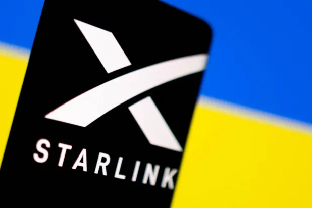 Starlink logo is seen on a smartphone in front of displayed Ukrainian flag in this illustration taken February 27, 2022. REUTERS/Dado Ruvic/Illustration