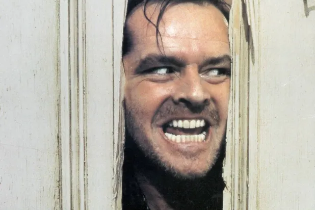 لقطة من الفيلم تحوّلت إلى أيقونة في سينما الرعب يُخرج فيها الممثل جاك نيكلسون رأسه من الباب المكسور (المصدر: IMDb)
