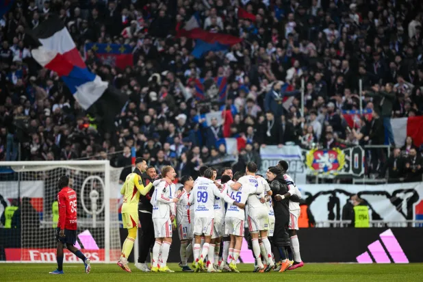 احتفالية لاعبي أولمبيك ليون مع جماهيرهم بهدف الفوز على ليل (أ.ف.ب)