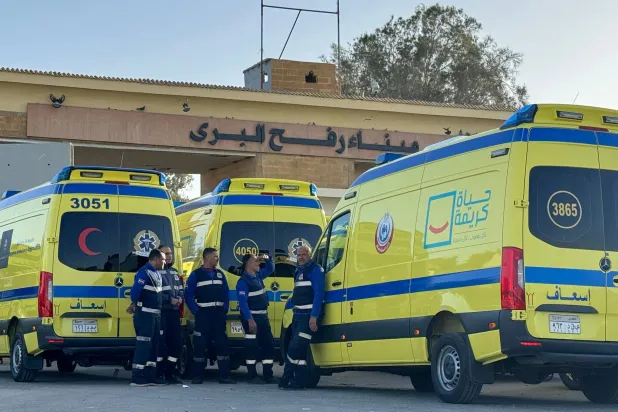 طواقم طبية مصرية تنتظر على الجانب المصري من معبر رفح أمس لنقل المرضى المتوقع خروجهم من قطاع غزة اليوم (أ.ف.ب)