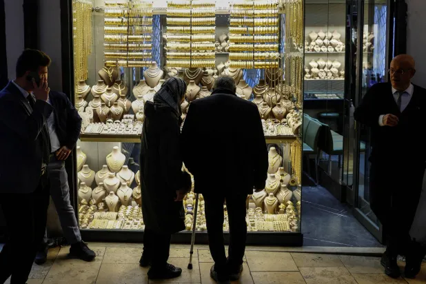 People look at gold jewelleries as they stand outside a jewellery shop at the Grand Bazaar in Istanbul, Türkiye, January 26, 2026. (Reuters)