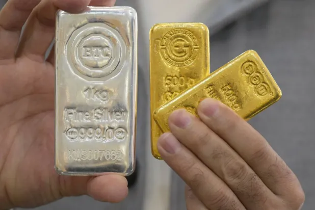 (FILES) A jeweler shows gold and silver bars at his shop in downtown Kuwait City on January 12, 2026. (Photo by YASSER AL-ZAYYAT / AFP)
