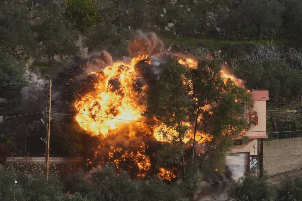 ألسنة لهب تتصاعد جراء استهداف إسرائيلي لمنزل في بلدة عين قانا بجنوب لبنان بعد إنذار بإخلائه (أ.ب)