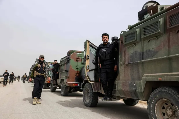 انتظار أفراد من القوات الحكومية السورية لبدء تحركاتهم على طريقٍ ريفيّ قرب مدينة الحسكة شمال شرقي سوريا صباح الاثنين (أ.ف.ب)