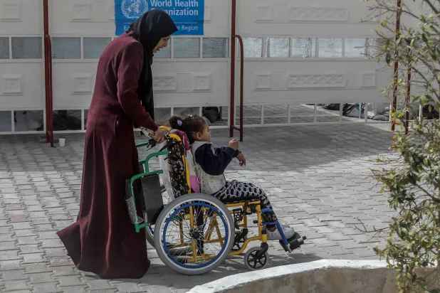 فلسطينية وطفلتها المصابة في خان يونس في انتظار الخروج من قطاع غزة (د.ب.أ)