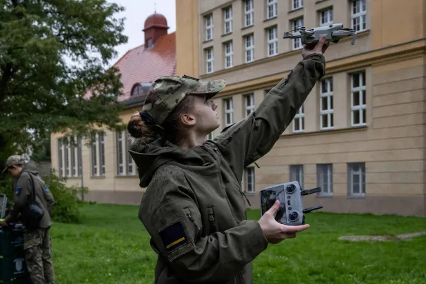 طالبة في الثانوية العسكرية في غرب بولندا تحرك طائرة مسيرة صغيرة - 8 أكتوبر 2025 (أ.ف.ب)